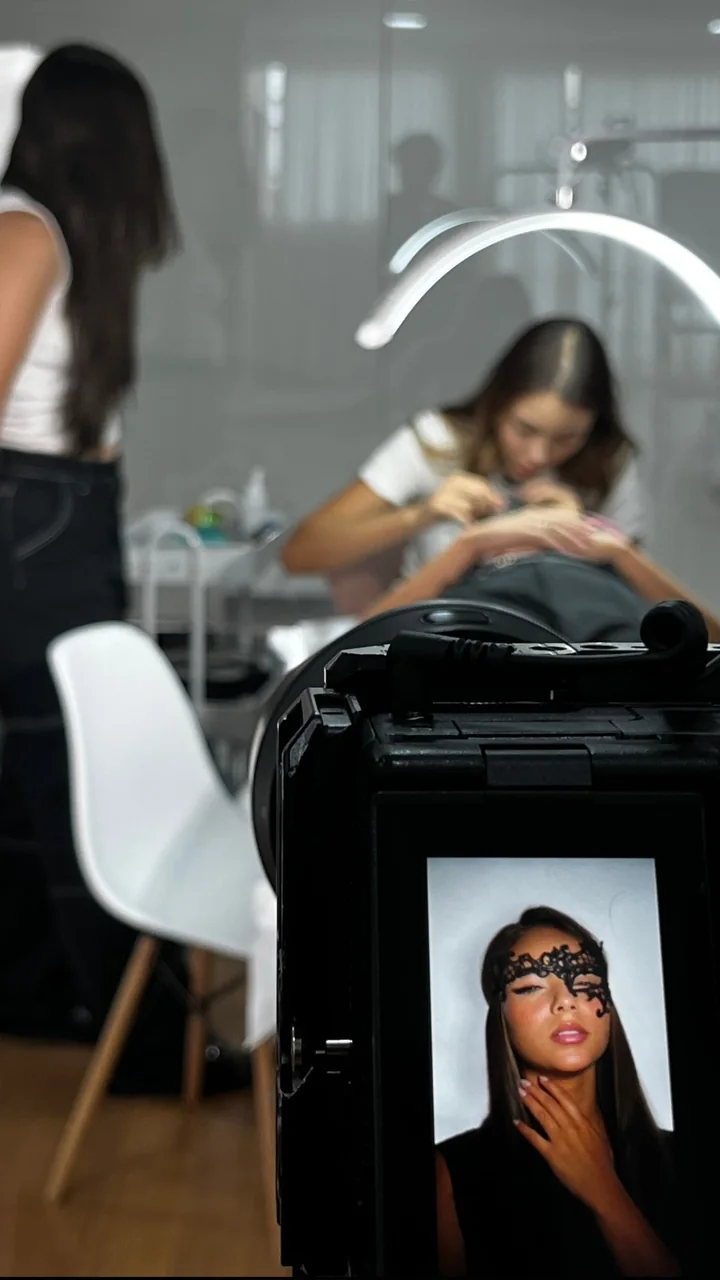 Bastidores de uma gravação em estúdio de estética, com a foto final no monitor da câmera