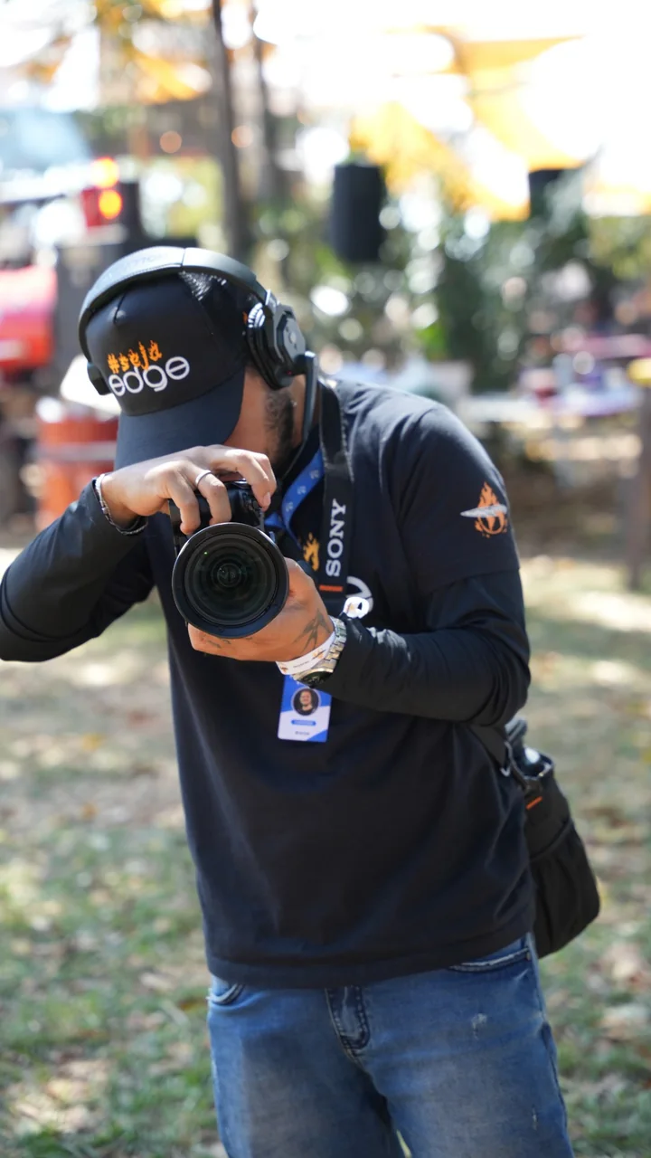 Fotógrafo da EDGE com boné #sejaedge registrando um evento ao ar livre